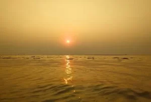 A scenic view of the sun rising over the horizon at a golden beach in Surat, featured on the 6 Days Rising Gujarat Tour.