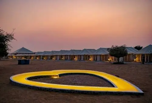 A beautifully lit luxury desert camp in Rajasthan under the night sky, a romantic destination featured in our Rajasthan honeymoon tour packages.