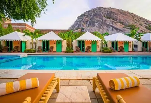 A tranquil poolside view at a luxury heritage property in Narlai, showcasing the relaxing atmosphere of our Rajasthan leisure tour packages.