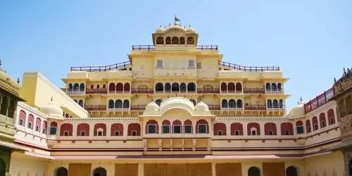 The stunning red and pink sandstone architecture of the majestic City Palace in Jaipur, featuring intricately carved arches and royal Rajput courtyards.