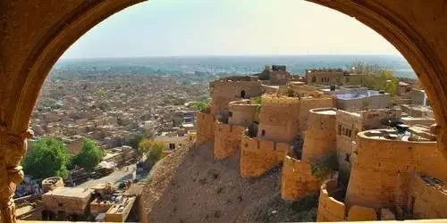 A panoramic sunset view of the majestic golden sandstone architecture of Jaisalmer Fort towering over the city in the Thar Desert, Rajasthan.