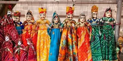 Colorful traditional Rajasthani string puppets, representing the vibrant cultural and festival themes available in our customized Rajasthan tour packages.